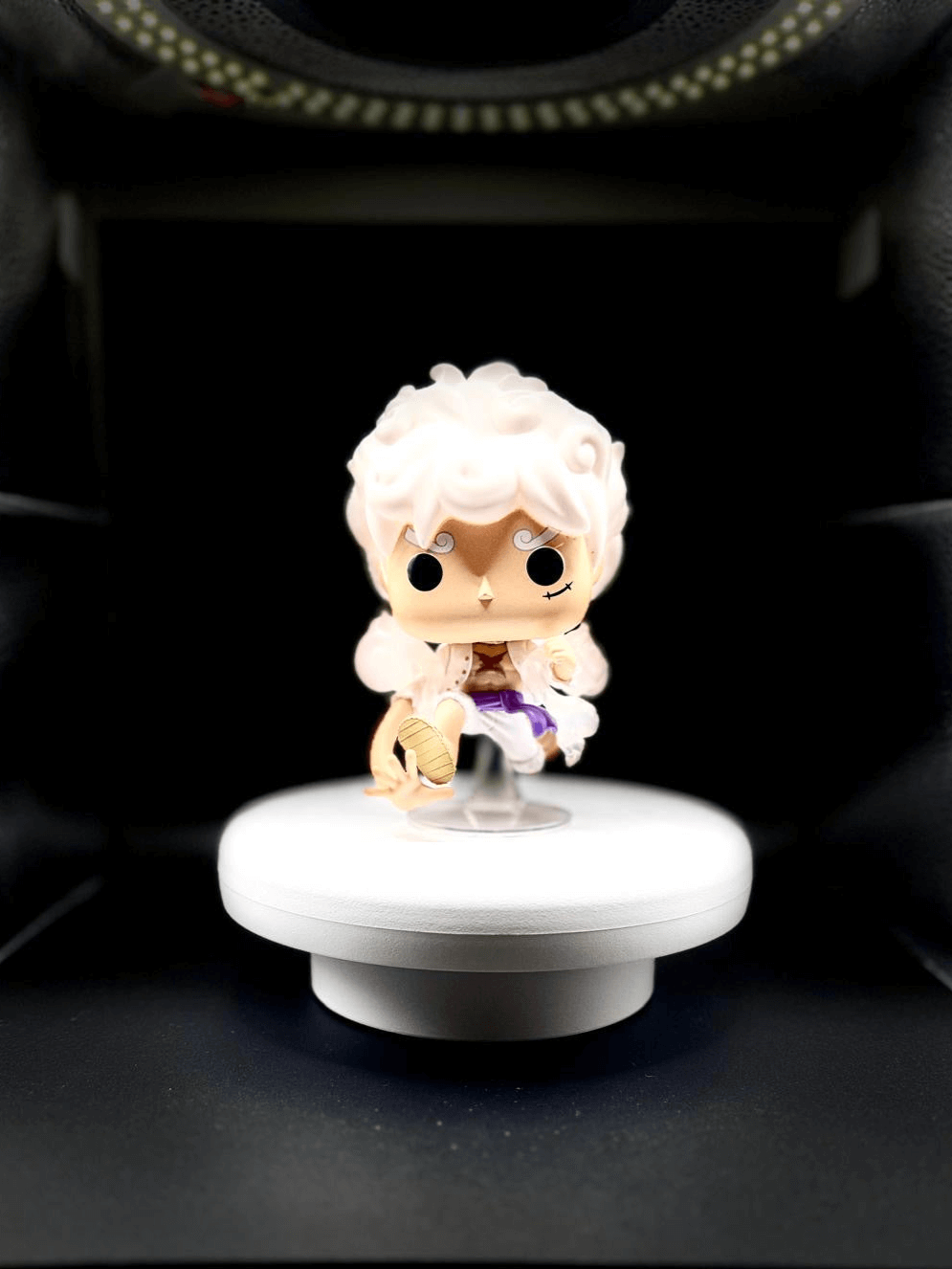 Funko Pop figurine of a character with white hair and unique outfit on a rotating display base.