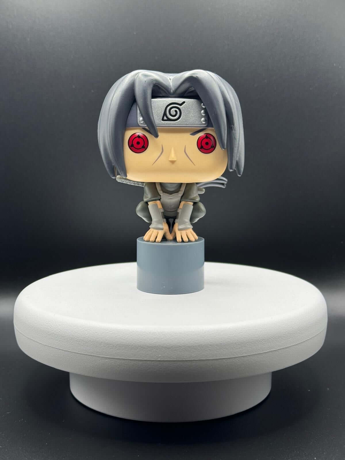 Funko Pop figure of Itachi Uchiha from Naruto, showcasing detailed design with red eyes and ninja attire.